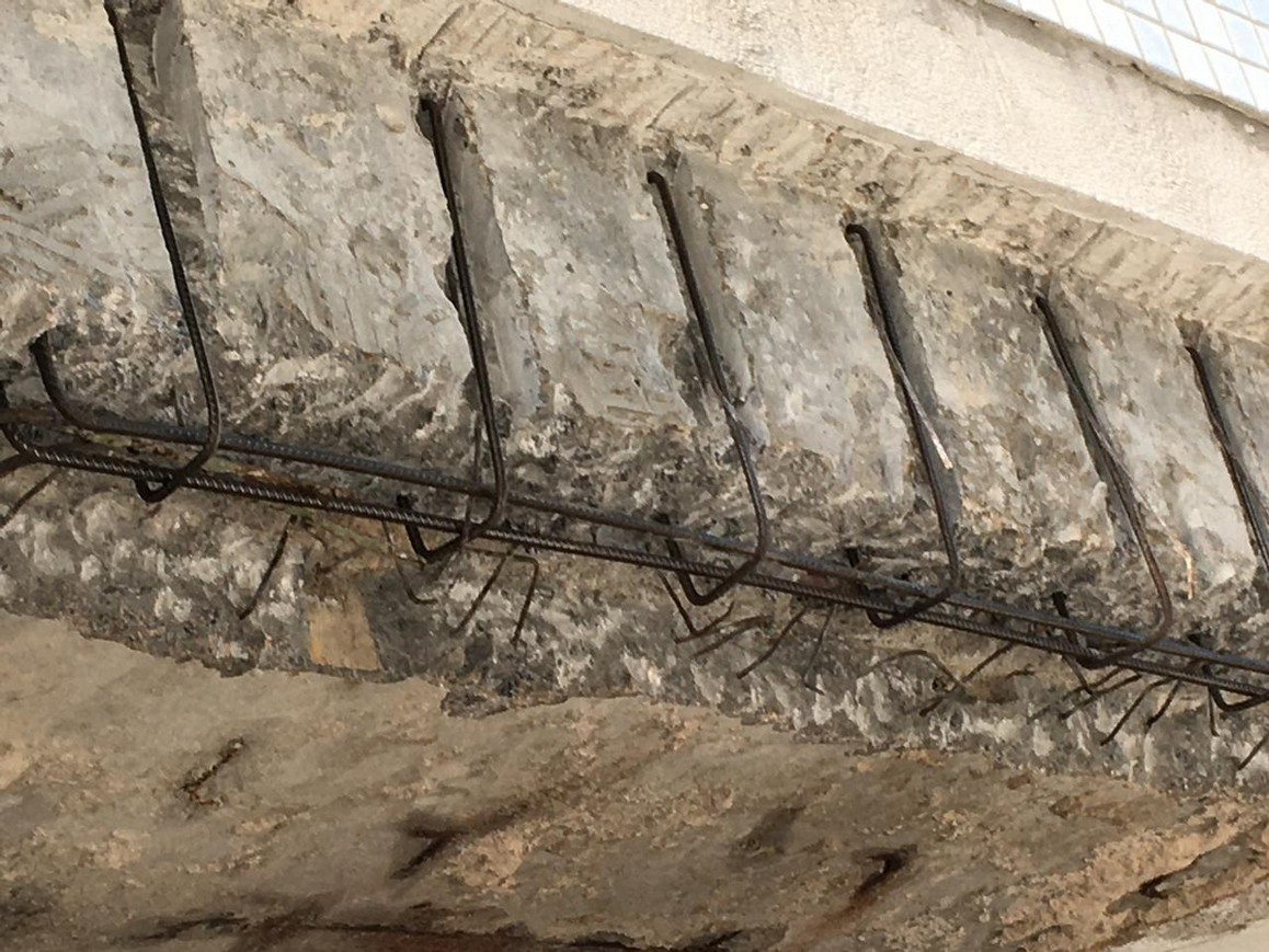 Deteriorated concrete removed from a concrete element with reinforcing steel exposed inside the defined repair area