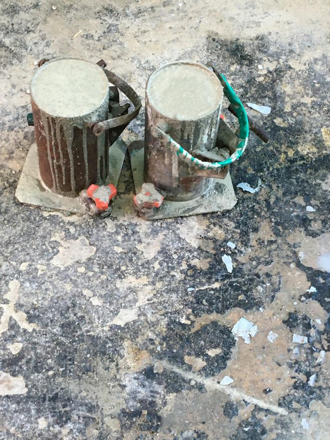 Equipment standing on a concrete floor slab where the surface finish has flaked away, exposing the substrate beneath