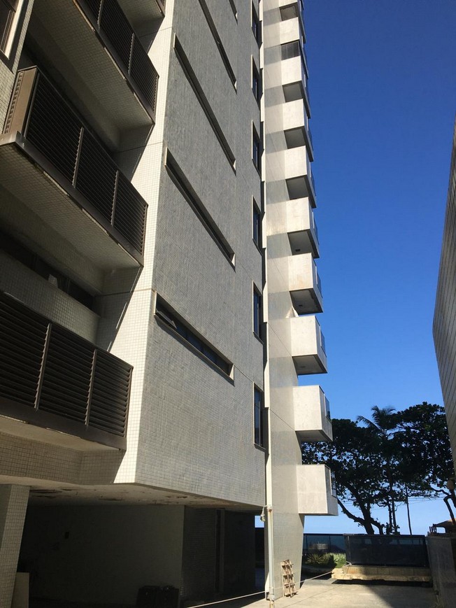 General view of a residential façade and balcony stacks after repair, with recomposed edges and reinstated finishes