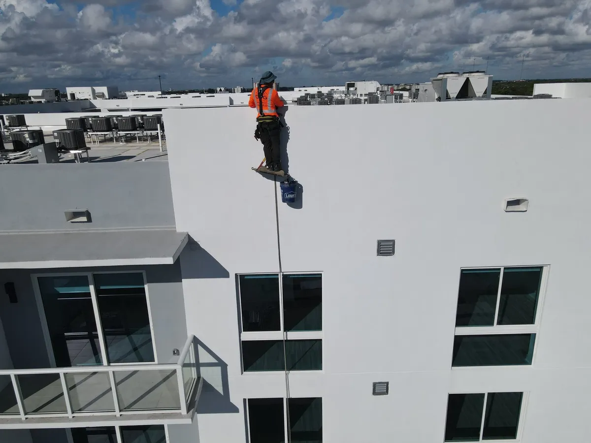 Rope access technician descending a building façade on ropes